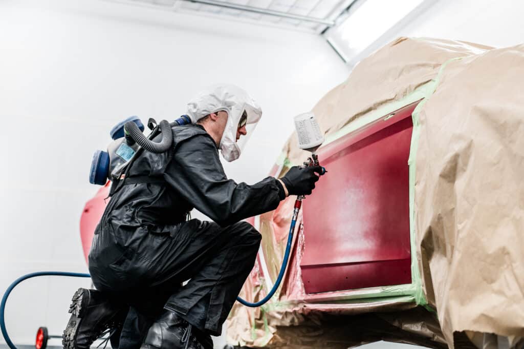 Lackierer in der Lackierkabine bei Auto Lang