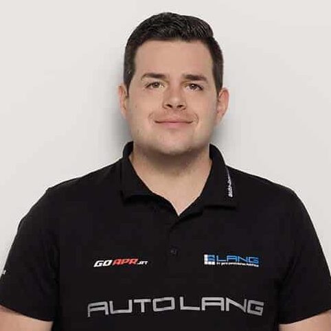 Gabriel Lang mit schwarzem T-Shirt, das die Aufschrift AUTO LANG trägt und das Auto Lang Logo aufgedruckt hat.